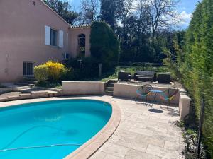a swimming pool with two chairs and a house at Gîte au Ventoux in Villes-sur-Auzon