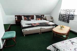 a bedroom with a bed and a chair and a table at Bagoly Fogadó in Gyömrő