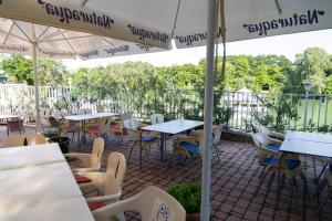an outdoor patio with tables and chairs and umbrellas at Bagoly Fogadó in Gyömrő +33 photos