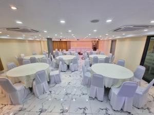 a banquet hall with white tables and white chairs at Bright Hotel in Petaling Jaya