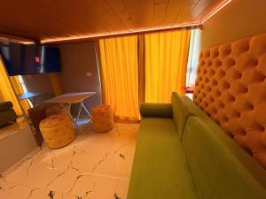 a living room with a green couch and a table at Romance Apartments in Sarandë