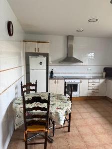 a kitchen with a table and chairs and a refrigerator at Les Eres de Palouet- Casa de campo con piscina privada in Palouet