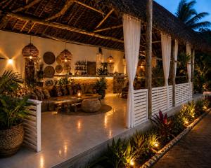 a resort patio with a couch and a table at Minah bungalows in Nungwi
