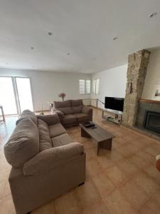 a living room with a couch and a fireplace at Les Eres de Palouet- Casa de campo con piscina privada in Palouet