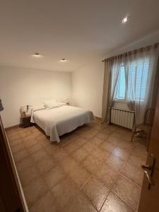 a bedroom with a white bed and a window at Les Eres de Palouet- Casa de campo con piscina privada in Palouet +16 photos