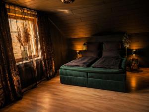 a bedroom with a green bed and a window at Emotion Apartments- BDSM Apartment mit privater Sauna in Vlotho