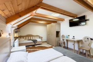 a bedroom with two beds and a desk at Pensiunea Mama Cozonacilor in Bran