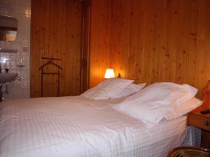 ein Schlafzimmer mit einem weißen Bett und einer Holzwand in der Unterkunft Pietra Serena 021 in Verbier