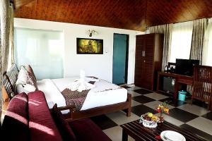 a bedroom with a bed and a couch in a room at Sunny's World Resort in Pune