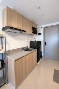 a kitchen with a sink and a black refrigerator at Ocean View Studio Iloilo in Iloilo City