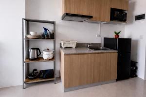 a kitchen with a sink and a black refrigerator at Ocean View Studio Iloilo in Iloilo City +1 photo
