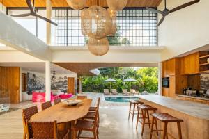 an open kitchen and dining room with a wooden table and chairs at Uluwatu Zen Villas in Badung