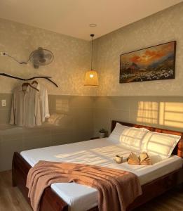 a bedroom with a bed with two shoes on it at Nếp Nhà Homestay in Tân Phú +15 photos