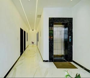 a hallway with white walls and a black and white door at Hotel Namaste Pushkar in Pushkar +19 photos