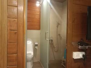 a bathroom with a toilet and a glass shower stall at Sunny's World Resort in Pune +53 photos