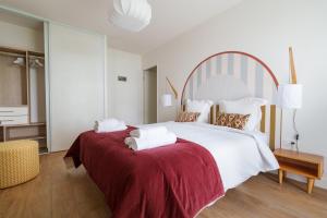 a bedroom with a large white bed with red sheets at L'Esplanade - T3 Design avec Parking et Mini-golf in Le Bouscat