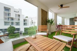 a patio with a wooden table and chairs on a balcony at L'Esplanade - T3 Design avec Parking et Mini-golf in Le Bouscat