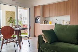 a living room with a green couch and a table at L'Esplanade - T3 Design avec Parking et Mini-golf in Le Bouscat
