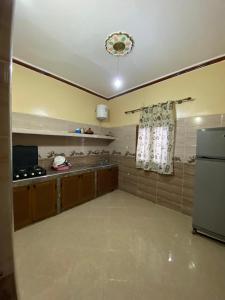 a large room with a kitchen with a refrigerator at Comfortable Luxury House in Merzouga