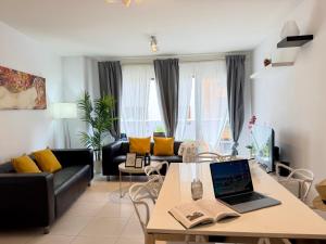 a living room with a table with a laptop on it at Hortensia Suites Apartments, Los Cristianos, Tenerife in Los Cristianos