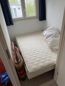 a small bed in a room with a window at Prachtig chalet in Koudum