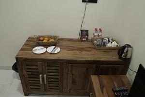 a wooden counter with plates and a basket of fruit at Sunny's World Resort in Pune
