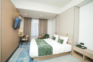 a hotel room with a bed and a desk at NOOMA Hotel Frunze in Bishkek