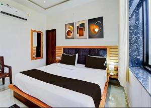 a bedroom with a large white bed and a window at Hotel Namaste Pushkar in Pushkar