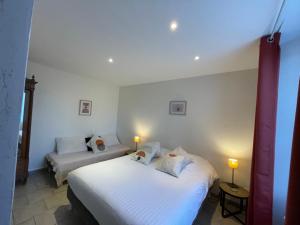 a bedroom with two beds and a couch in it at Gite CARAMELLE Piscine intérieure privée chauffee toute l annee et spa St Martin in Saint-Martin-lʼHortier +14 photos