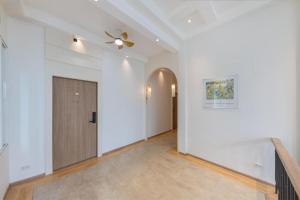 a hallway with a door and a ceiling fan at Upstairs at Ton Ton in Bangkok