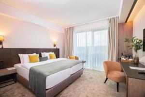 a hotel room with a large bed and a desk at Montello Hotel in Balatonfüred