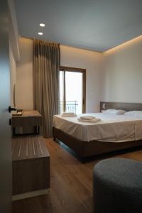 a hotel room with two beds and a window at Pissouriana hotel Apartments in Pissouri +21 photos
