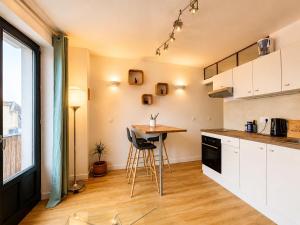 a kitchen with white cabinets and a table in it at Éclat d'Écume - Vue mer - Hypercentre - 31 M2 - Quiberon in Quiberon