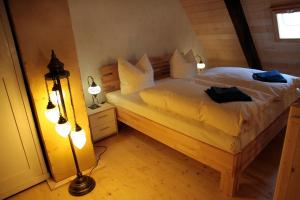 Schlafzimmer mit einem Bett mit weißer Bettwäsche und Kissen in der Unterkunft Kristallhaus anno 1438 in Quedlinburg