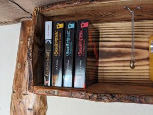 a group of books on a wooden shelf at La Maison de Hobbit in Lafarre