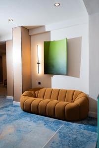 a large brown couch in a room with a green screen at NOOMA Hotel Frunze in Bishkek