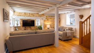 a living room with a couch and a tv at Garden Cottage in Chipping Campden