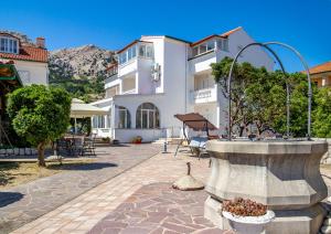 a courtyard with a fountain in front of a building at Bed & Breakfast Haus Lucija in Baška