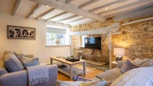 a living room with a stone wall at Garden Cottage in Chipping Campden