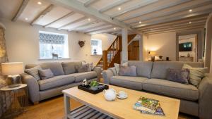 a living room with two couches and a coffee table at Garden Cottage in Chipping Campden