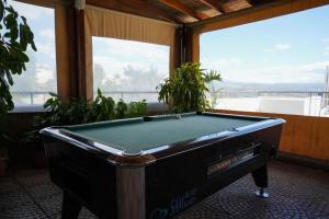 a pool table in a room with windows at Pissouriana hotel Apartments in Pissouri