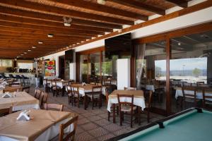 a restaurant with tables and chairs and a pool table at Pissouriana hotel Apartments in Pissouri