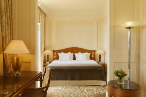 a hotel room with a bed and two tables at Hotel Palace Portoroz by Minor Hotels in Portorož