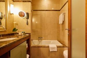 a bathroom with a tub and a sink and a toilet at Hotel Palace Portoroz by Minor Hotels in Portorož