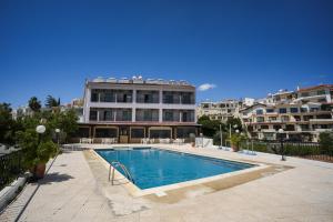 a swimming pool in front of a building at Pissouriana hotel Apartments in Pissouri