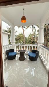 a porch with chairs and a table on a balcony at Riverside By GikiJoy in Agarvado