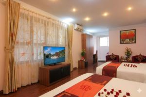 a hotel room with two beds and a flat screen tv at Urban Alley Hotel in Hanoi