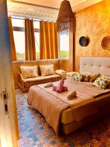 a bedroom with a large bed and a couch at Zeri Surf Taghazout Hiltop in Taghazout +44 photos
