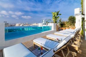 a row of lounge chairs on the roof of a building at H10 Puerta de Alcalá 4 Sup in Madrid