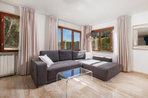 a living room with a couch and a glass table at Villa The Nest in Opatija
